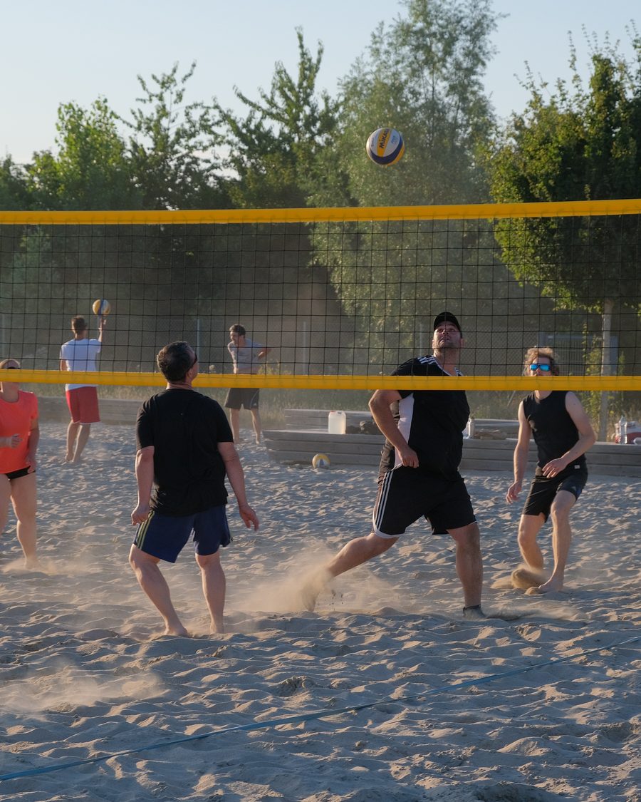 Une partie de volley entre collègues sur un terrain extérieur