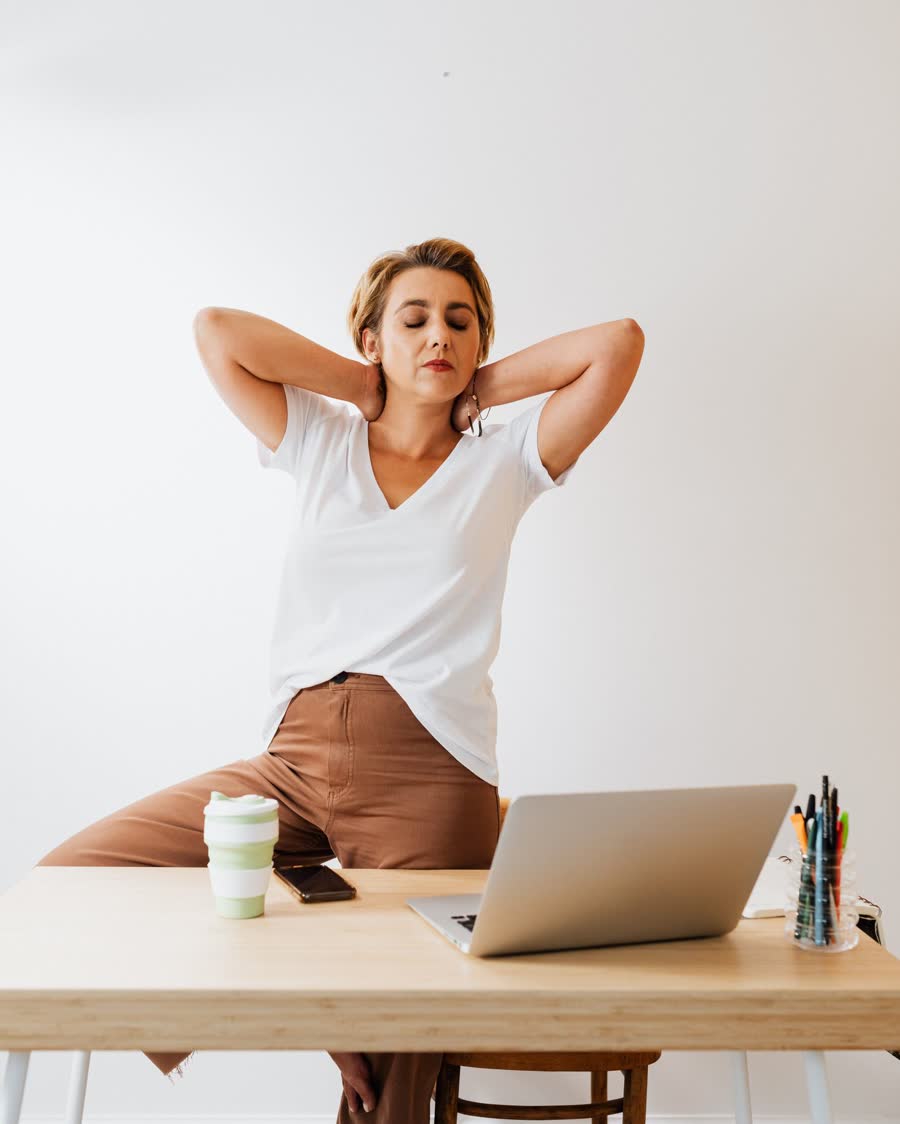 Une salariée s'étire à son bureau pendant une pause